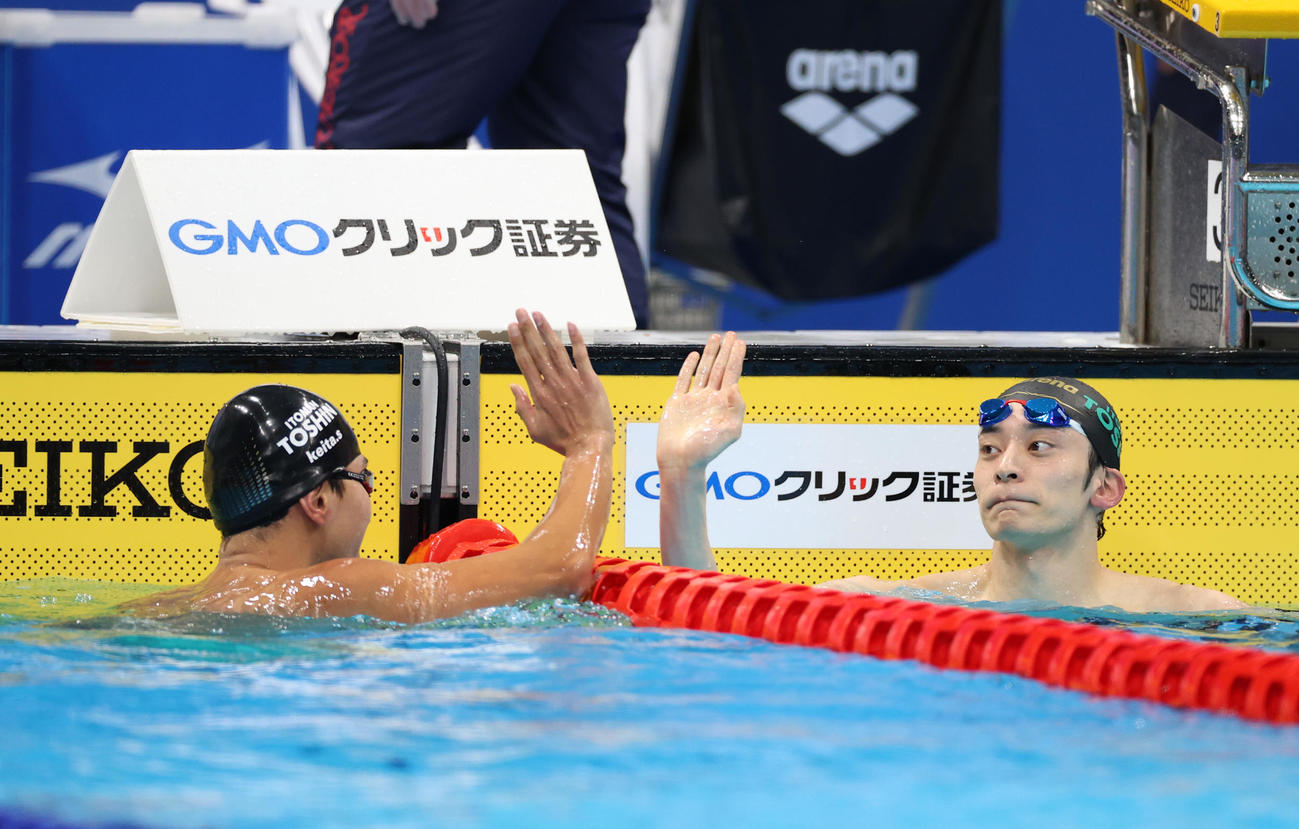 男子200メートル背泳ぎで優勝した入江（右）は2位の砂間とハイタッチを交わす（撮影・河野匠）