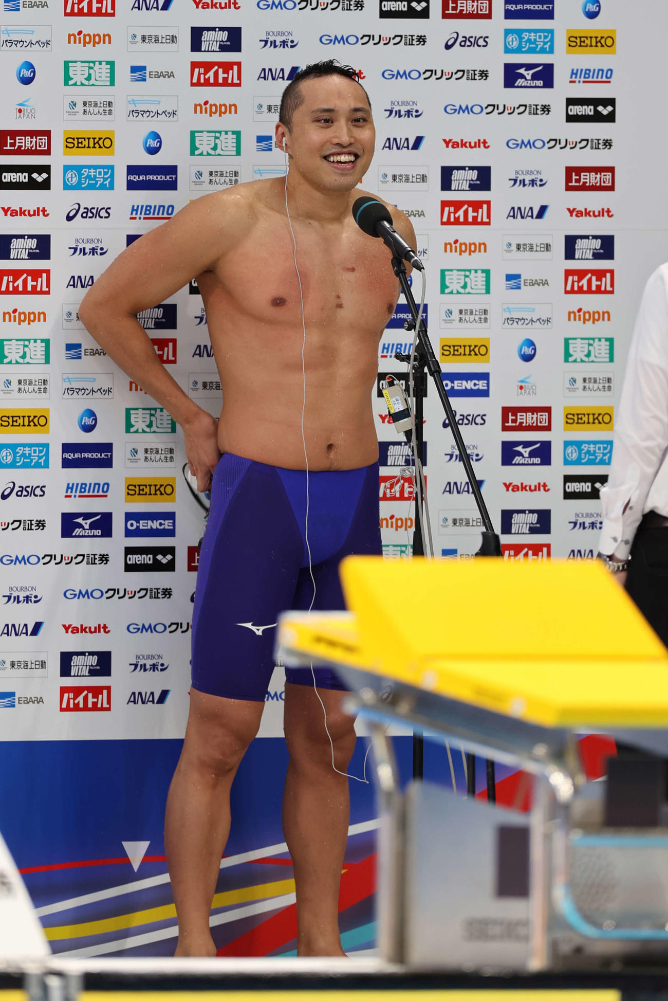 男子50メートル自由形で優勝しインタビューで新婚の話をふられて笑顔を見せる塩浦（撮影・河野匠）