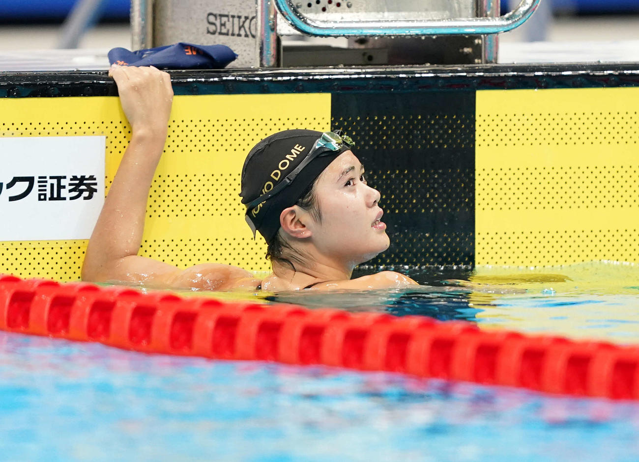 女子200メートルバタフライで優勝し、タイムを見る長谷川（撮影・鈴木みどり）