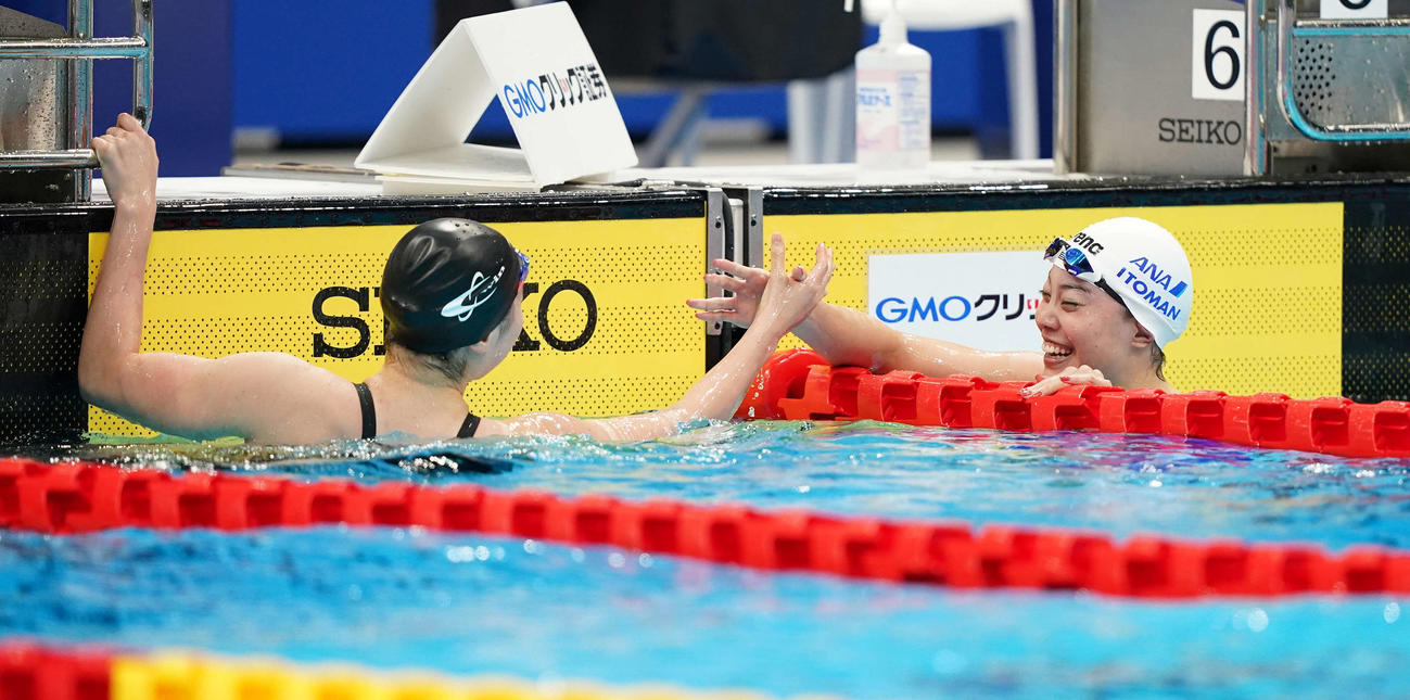 女子100メートル自由形で同着で優勝し、握手する酒井（左）と大本（撮影・鈴木みどり）