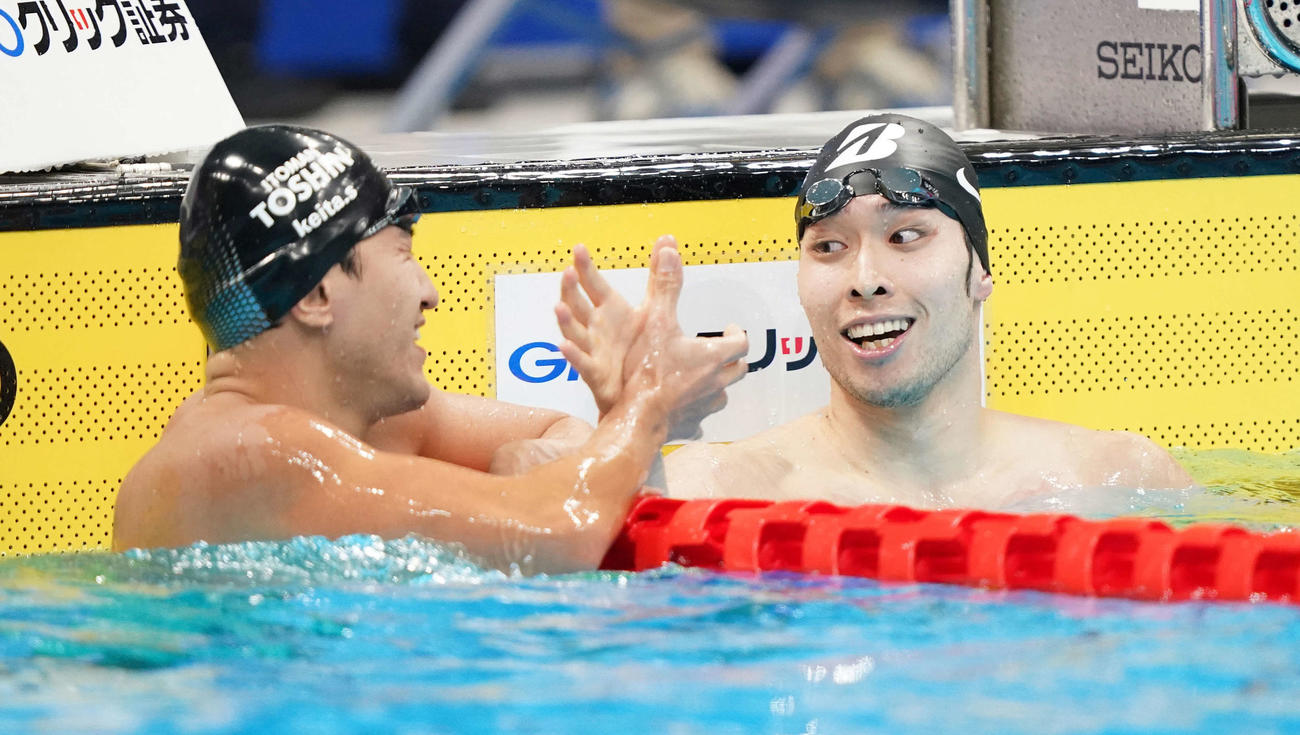 男子200メートル個人メドレーで優勝した萩野（右）は砂間と握手（撮影・鈴木みどり）