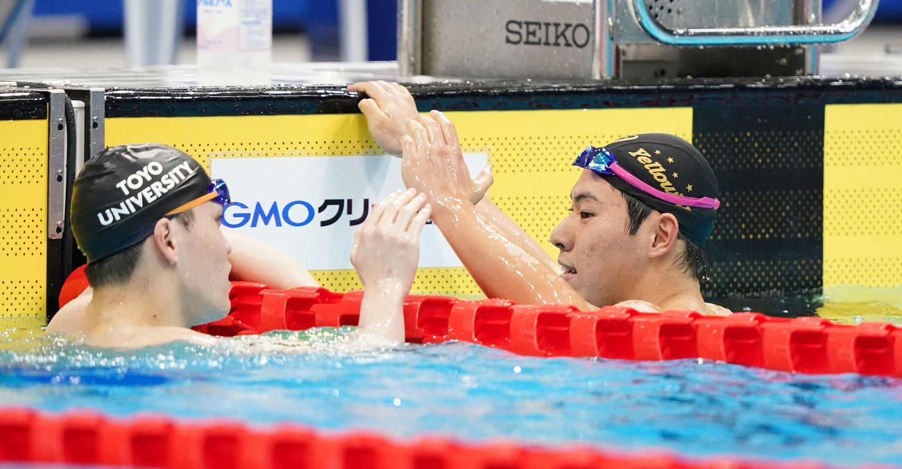 男子200メートルバタフライで優勝し笑顔の本多（右）。左は阪本（撮影・鈴木みどり）