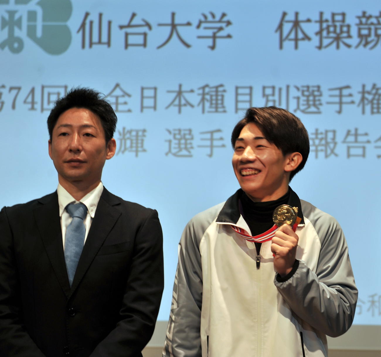 全日本体操個人別選手権でゆか連覇を達成した仙台大の南（右）は鈴木監督と笑顔で優勝報告会にに行う