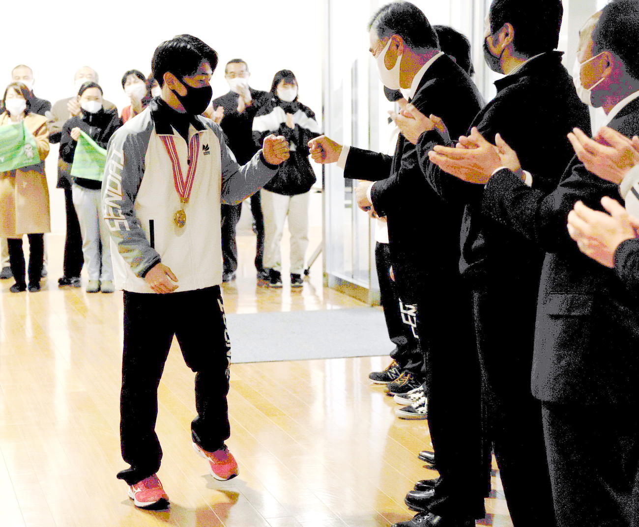 全日本体操種目別選手権ゆか2連覇の南（左）は、仙台大の関係者に迎えられて優勝報告会に臨む