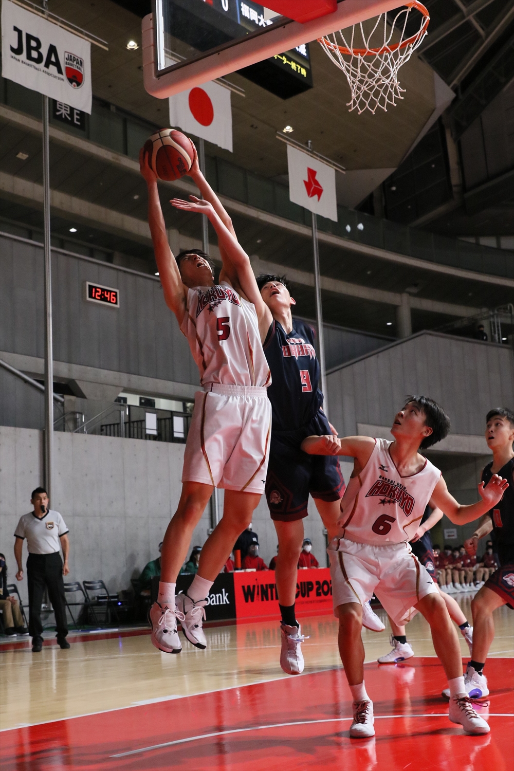 福岡大大濠対関大北陽　第1Q、ゴール下で競り合う関大北陽・森田壮（中央左）と福岡大大濠・泉登翔（同右）（C）JBA