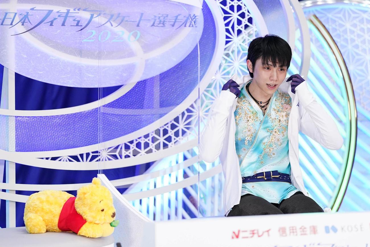 全日本フィギュアスケート選手権　男子フリーの演技を終え、「キス・アンド・クライ」でくまのプーさんと並んで座る羽生（代表撮影）
