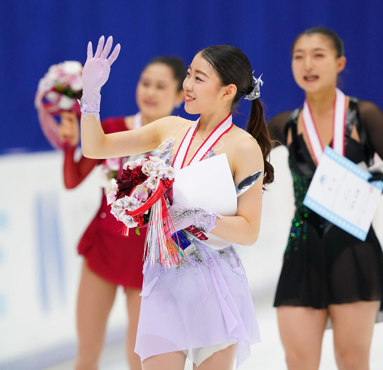 歓声に応える女子で優勝した紀平。右は2位の坂本、左は3位の宮原（代表撮影）