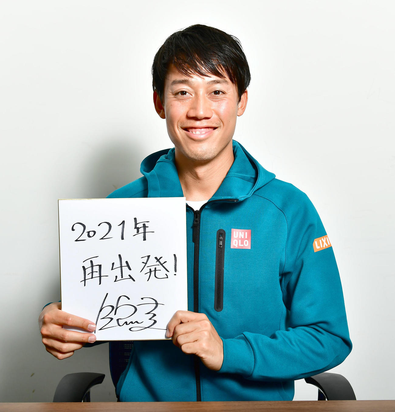 新年の目標を「再出発！」と記した色紙を手に笑顔を見せる錦織（撮影・小沢裕）