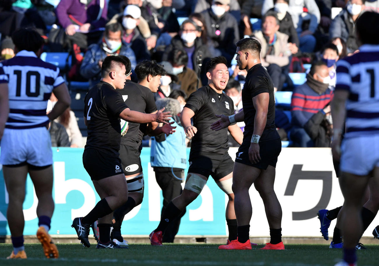 天理大対明大　前半、トライを決め祝福される天理大フッカー佐藤（左）（撮影・滝沢徹郎）