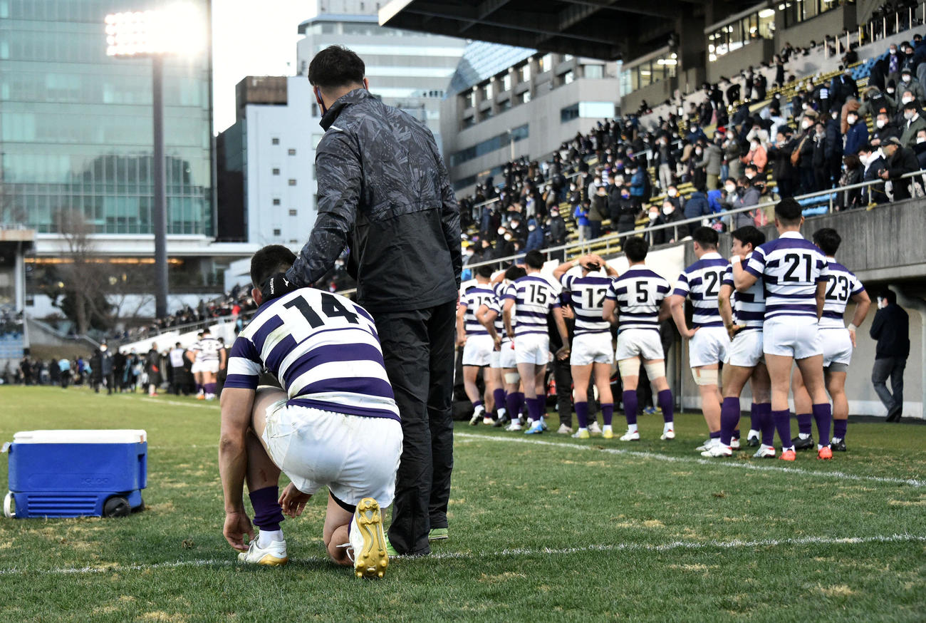 天理大対明大　試合後、明大プロップ石川（左）を称えるスタッフと悔しげにピッチを去るフィフティーン（撮影・滝沢徹郎）