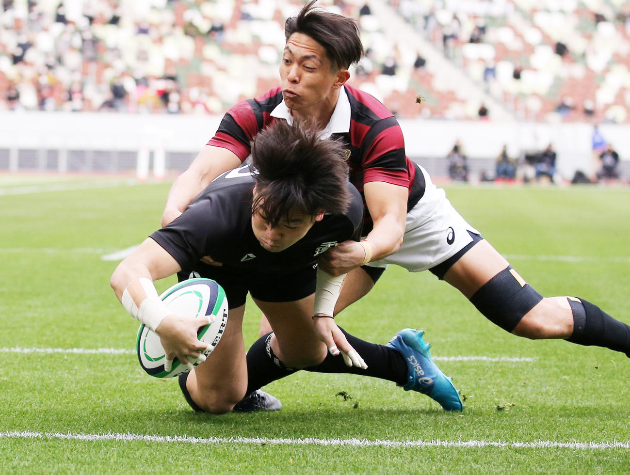 前半、タックルを受けながらも先制トライを決める天理大CTB市川（撮影・野上伸悟）