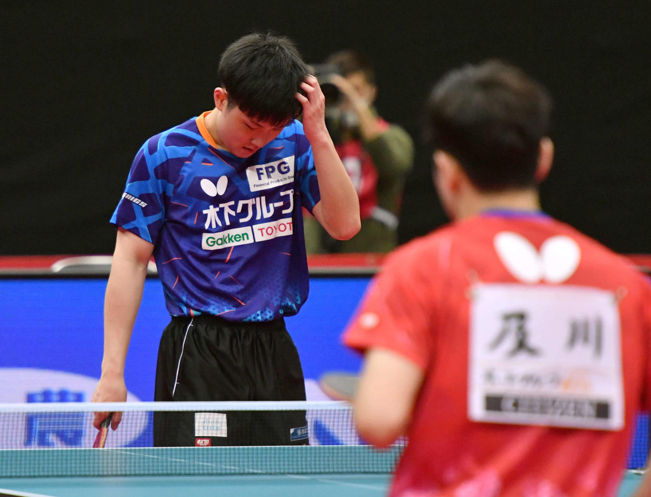 全日本卓球選手権男子シングルス準々決勝　ミスで失点し頭を抱える張本智和、右は及川瑞基（撮影・岩下翔太）