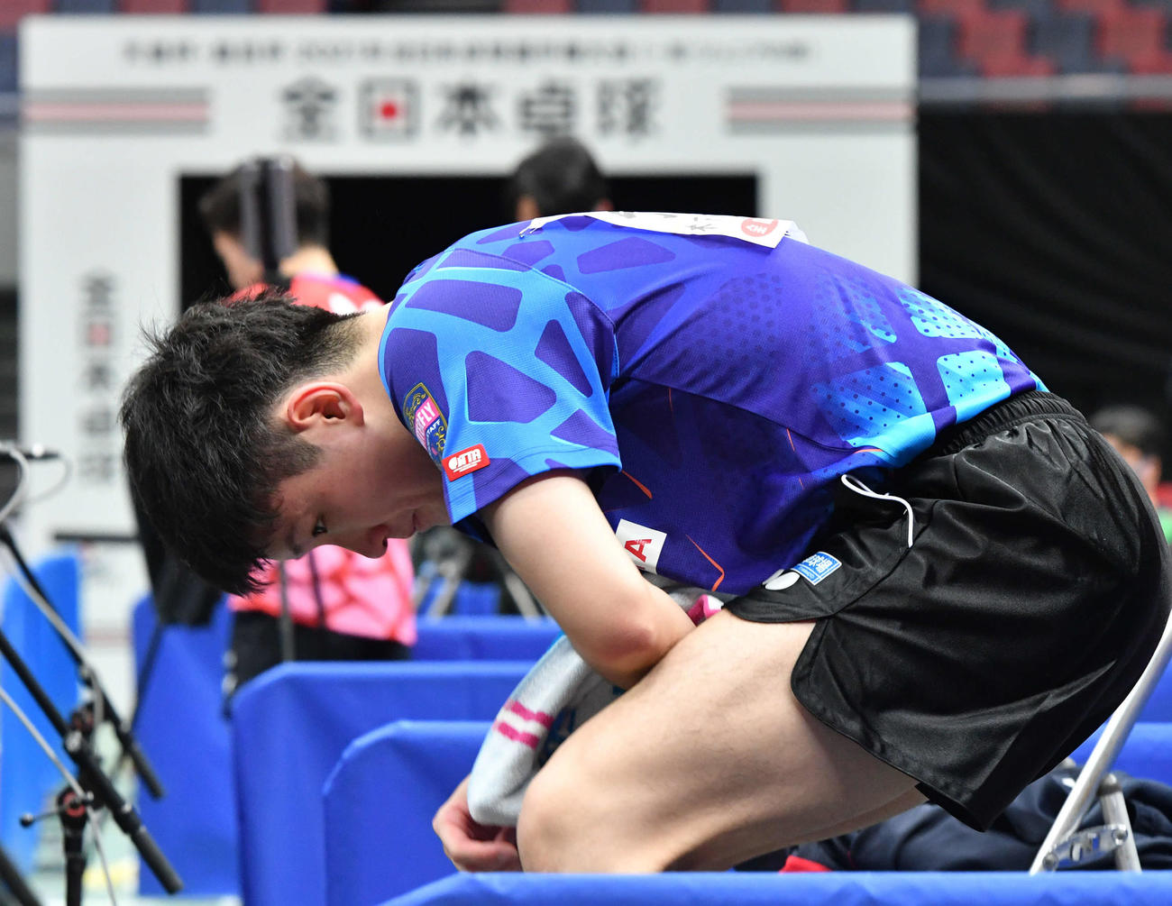 全日本卓球選手権男子シングルス準々決勝　3ゲームを連続で奪われ後がなくなり、厳しい表情で椅子から立ち上がる張本智和（撮影・岩下翔太）