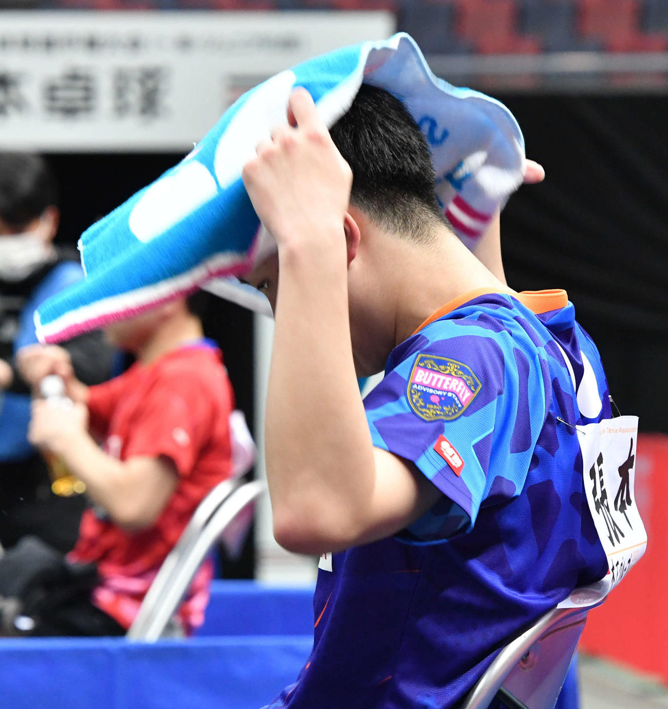 全日本卓球選手権男子シングルス準々決勝　3ゲームを連続で奪われ後がなくなり、厳しい表情でタオルを頭にかぶる張本智和（撮影・岩下翔太）