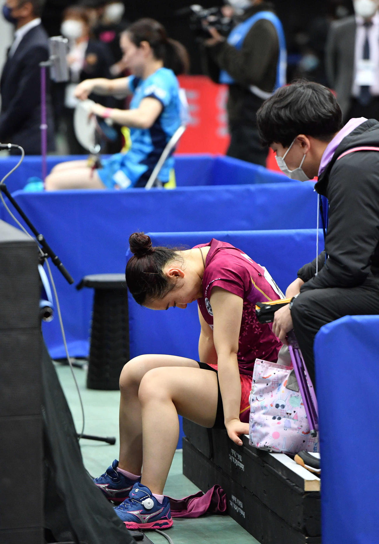 全日本卓球選手権　女子シングルス決勝で石川佳純（奥）に敗れ、ベンチで肩を落とす伊藤美誠（撮影・岩下翔太）