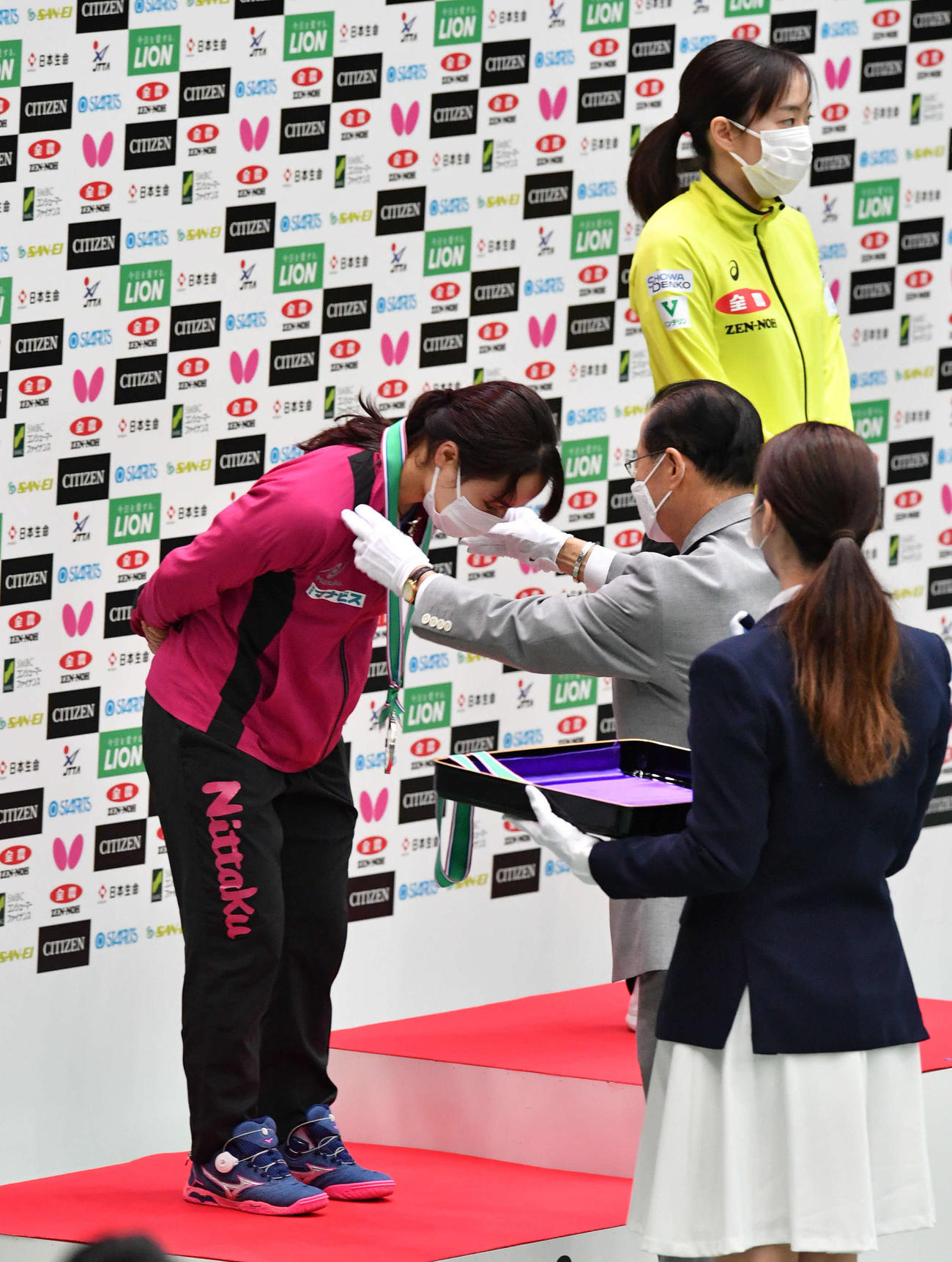 全日本卓球選手権　表彰式でメダルを授与される伊藤美誠（左）、右奥は石川佳純（撮影・岩下翔太）