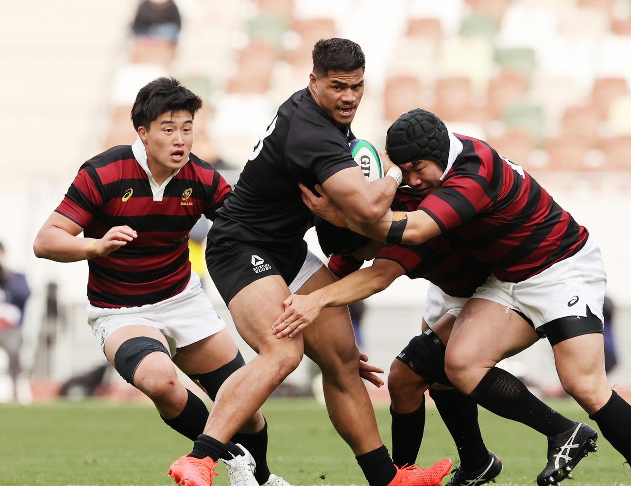 大学選手権決勝で相手に囲まれながらも突進する天理大CTBフィフィタ（2021年1月11日撮影）