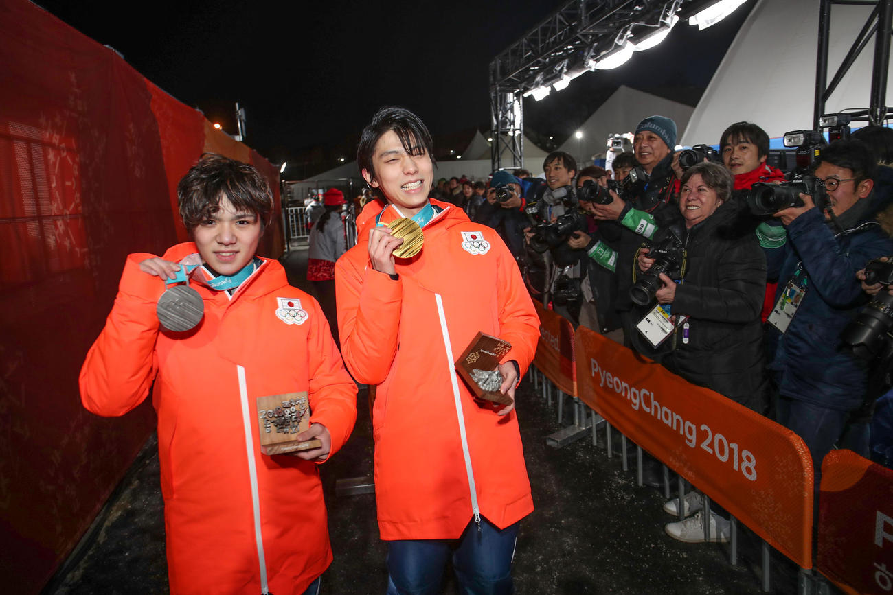 18年2月、平昌五輪フィギュアスケートのメダルセレモニーで笑顔を見せる金メダルの羽生（右）と銀メダルの宇野