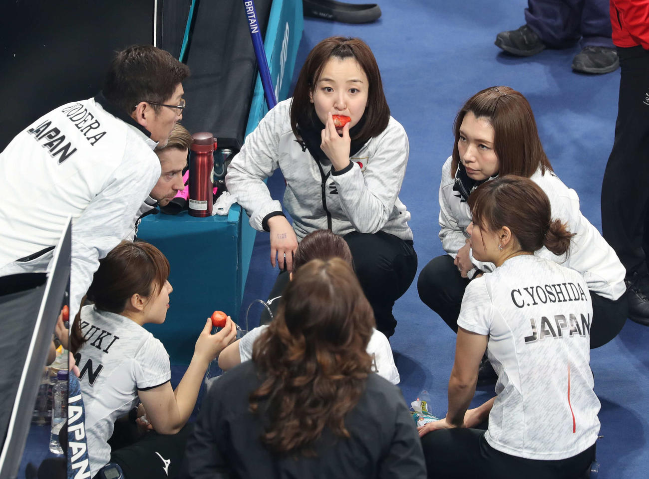 平昌五輪カーリング女子3位決定戦　藤沢五月（中央）は大きないちごを頬張りながら作戦を練る。右はリザーブ本橋麻里（2018年2月24日撮影）