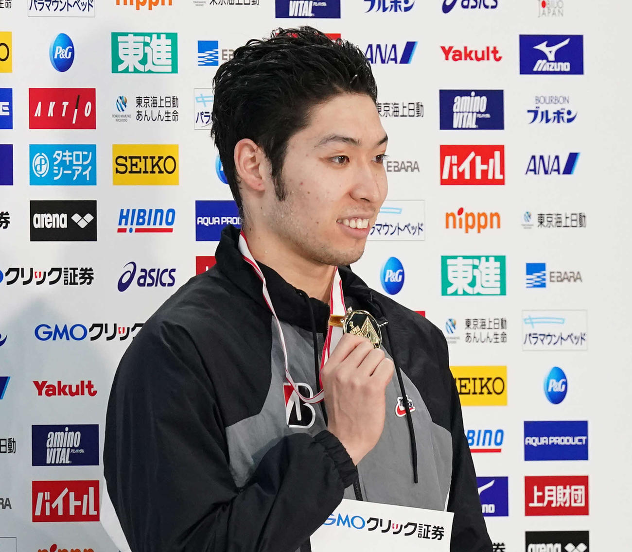 男子200メートル個人メドレーで優勝し、メダルを手に笑顔の萩野（撮影・鈴木みどり）