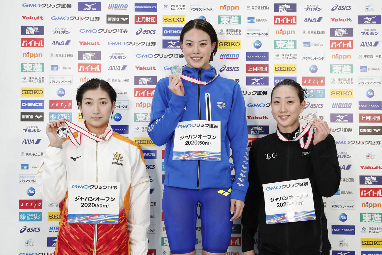 女子50メートル自由形で2位の池江（左）は表彰式でメダルを手にする。中央は優勝の大本、右は3位の五十嵐（日本水泳連盟提供）