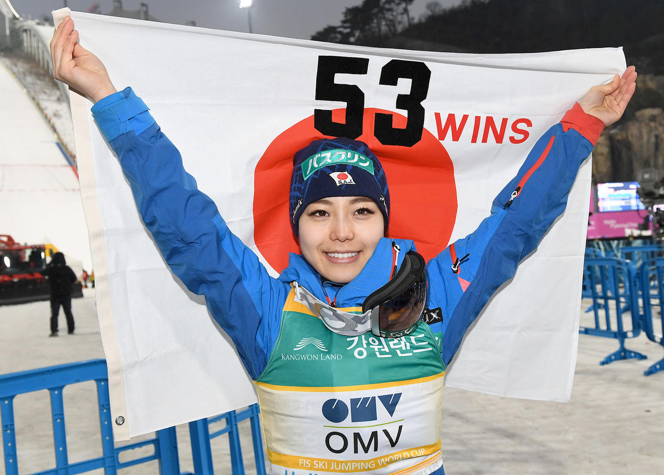 Ｗ杯５３勝目を挙げた高梨は日の丸を掲げて笑顔を見せる（撮影・山崎安昭）