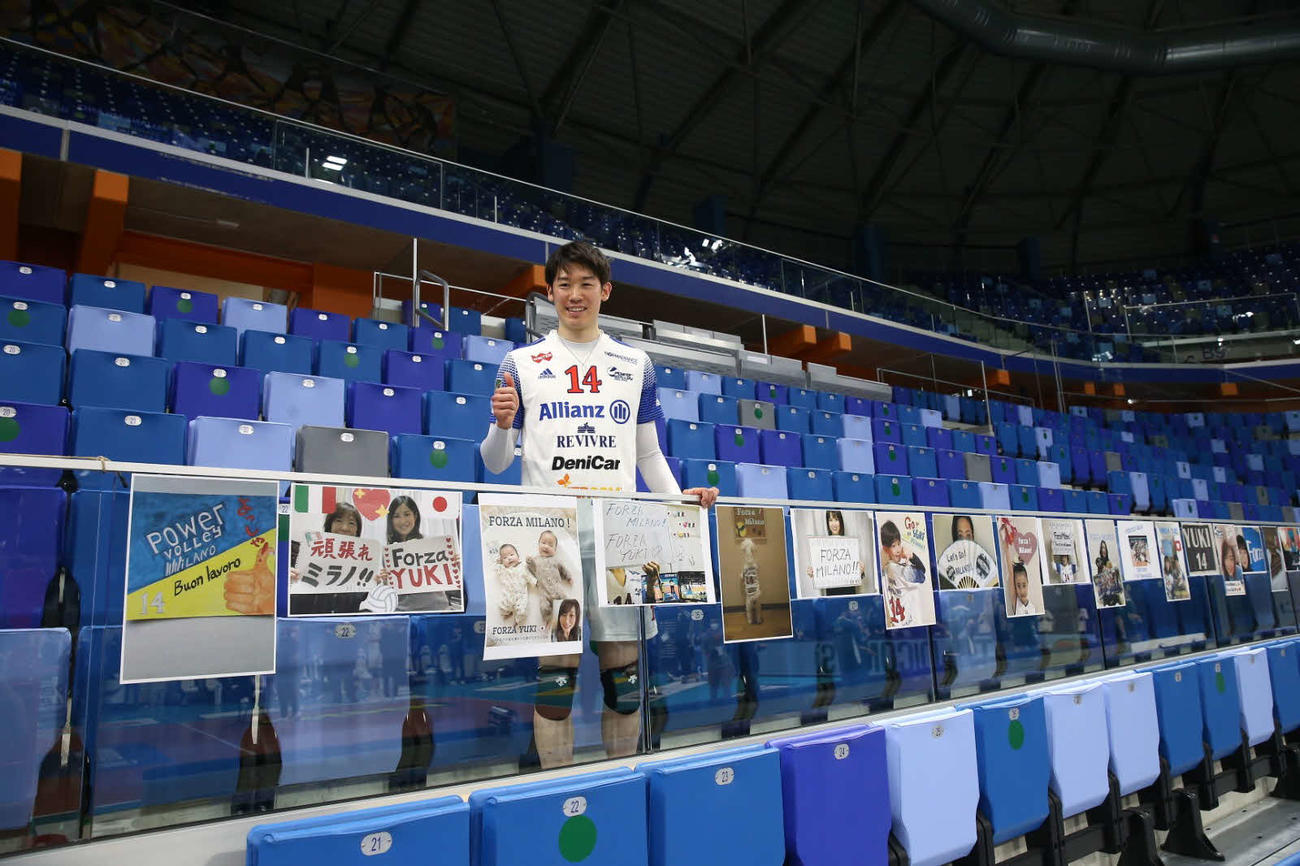 日本のサポーターからの応援写真が並べられた試合会場で笑顔を浮かべる石川（所属事務所提供）