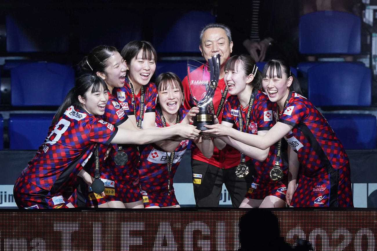 優勝を決め笑顔でシャーレを掲げる日本生命の選手たち。左から麻生、森、平野、前田、村上監督、早田、赤江（撮影・鈴木みどり）