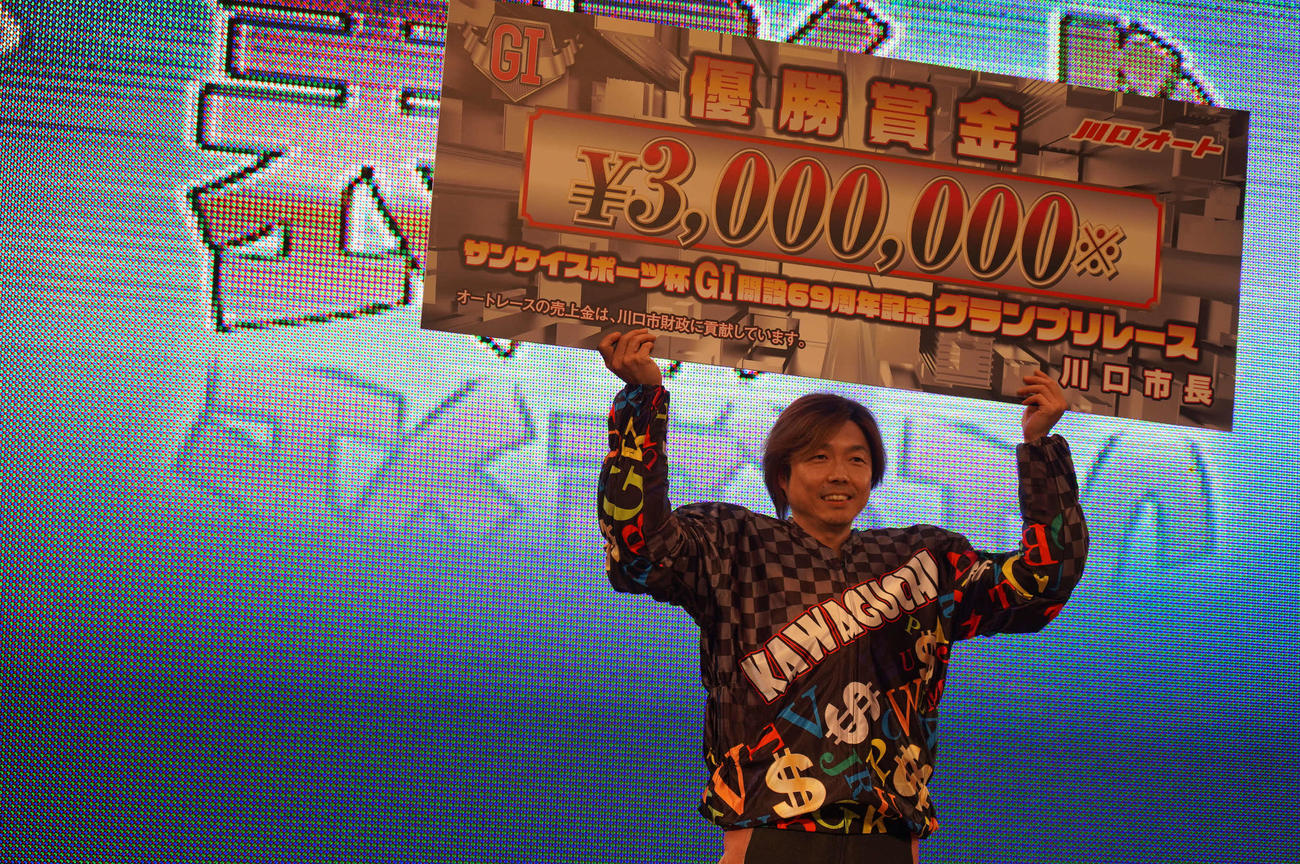 有吉辰也が川口オート開設69周年記念グランプリレースを逃げ切り、賞金ボードを掲げて笑顔（撮影・木村重成）