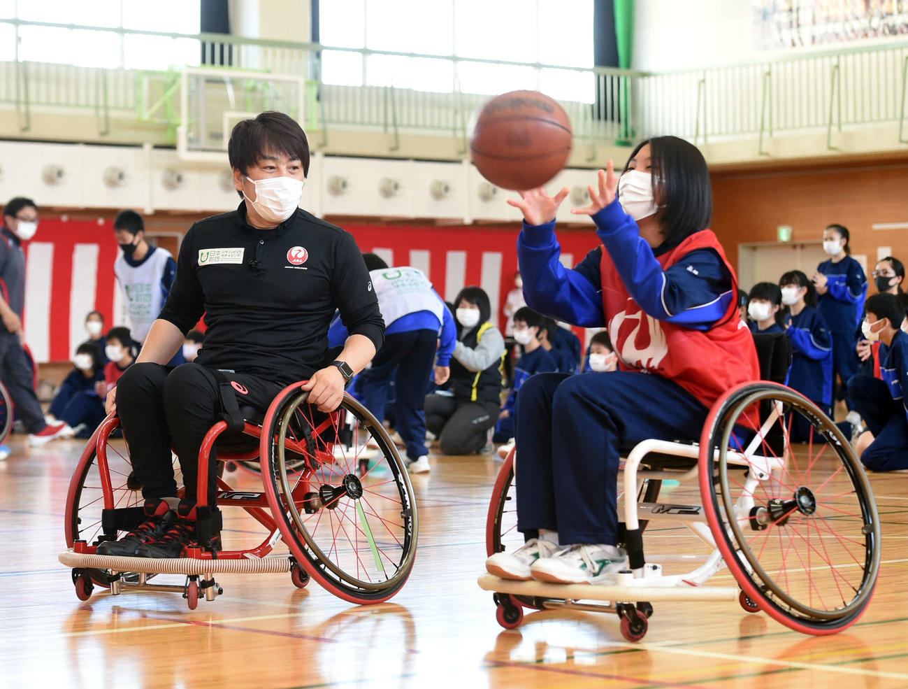 中学生が体験する様子を見守る根木氏（左）（撮影・相沢孔志）