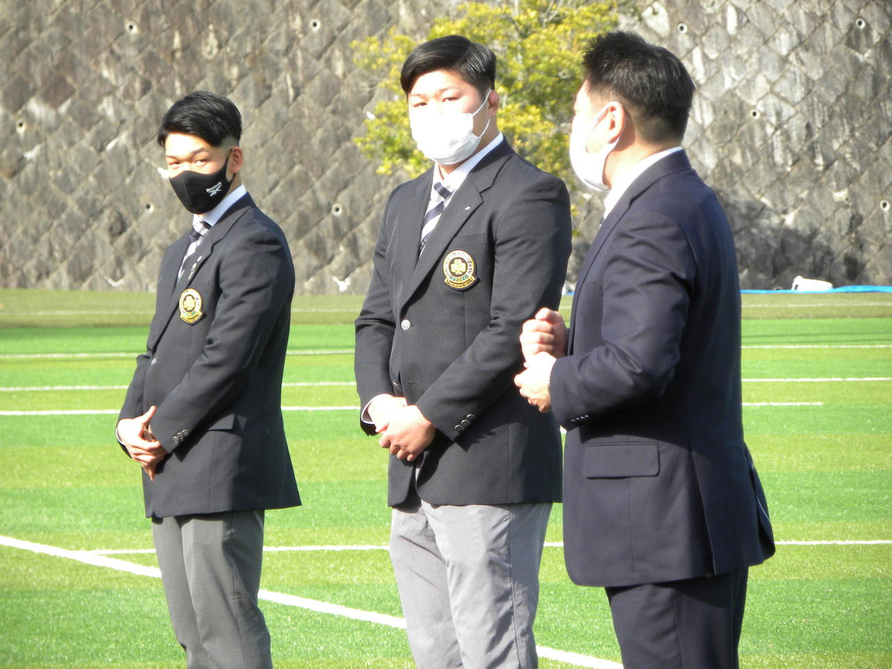伊藤紀晶ヘッドコーチ（右）から声をかけられる同大新主将のロック南光希（中央）、SH田村魁世（左）（撮影・松本航）