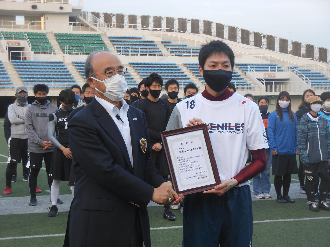日本アメリカンフットボール協会国吉会長（左）から賞状を贈られた優勝の京都ジュベナイルズ平井主将