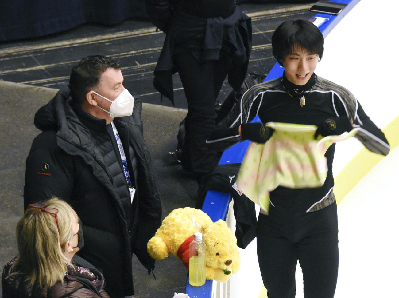 公式練習で談笑する羽生結弦（右）とマスク姿のオーサー・コーチ（共同）
