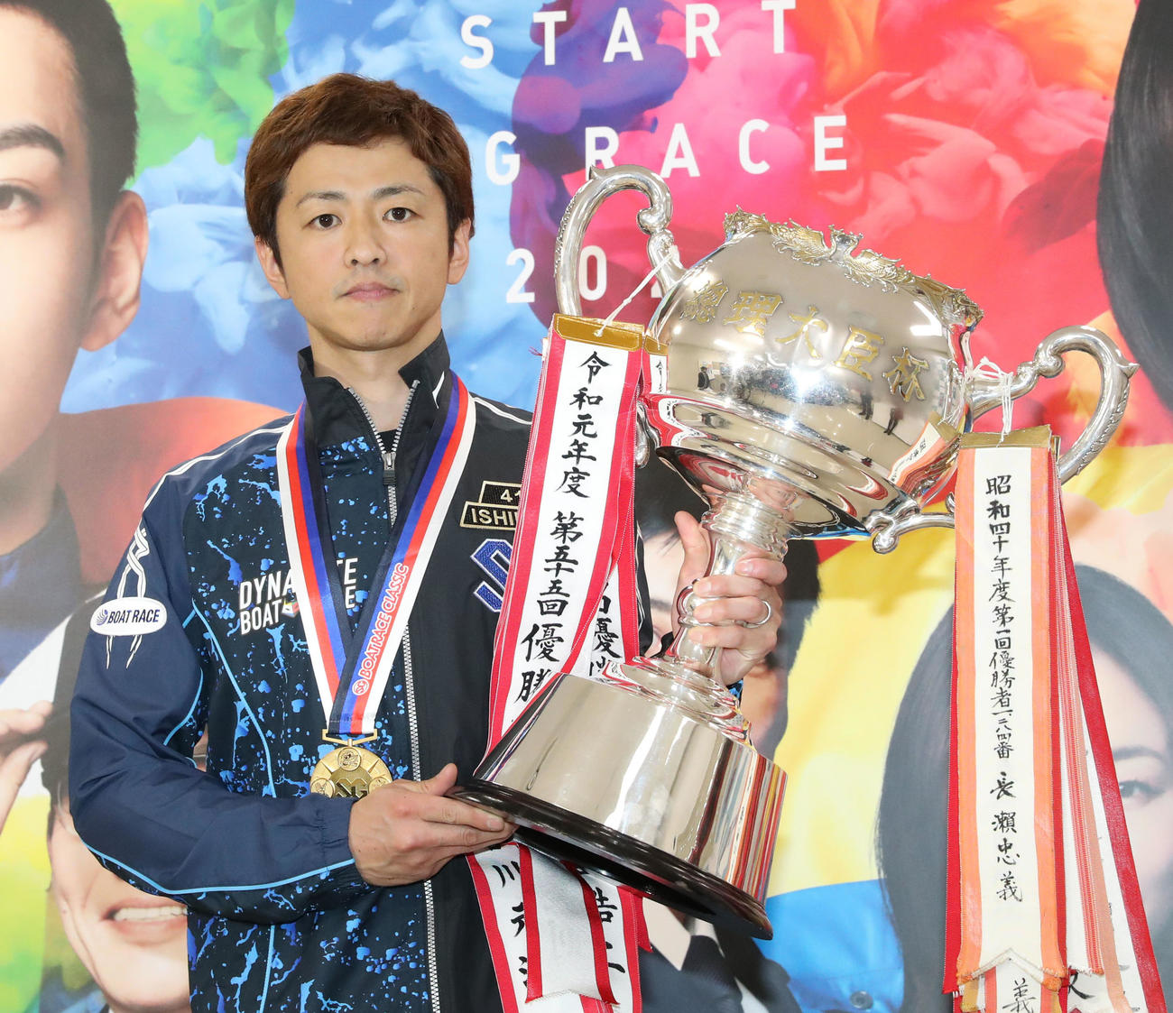 優勝トロフィーを手にする石野貴之（撮影・屋方直哉）
