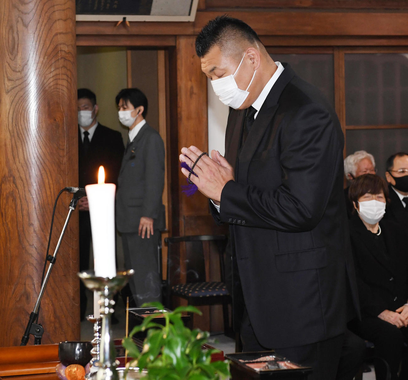 祭壇に向かって手を合わせる小川直也氏（代表撮影）
