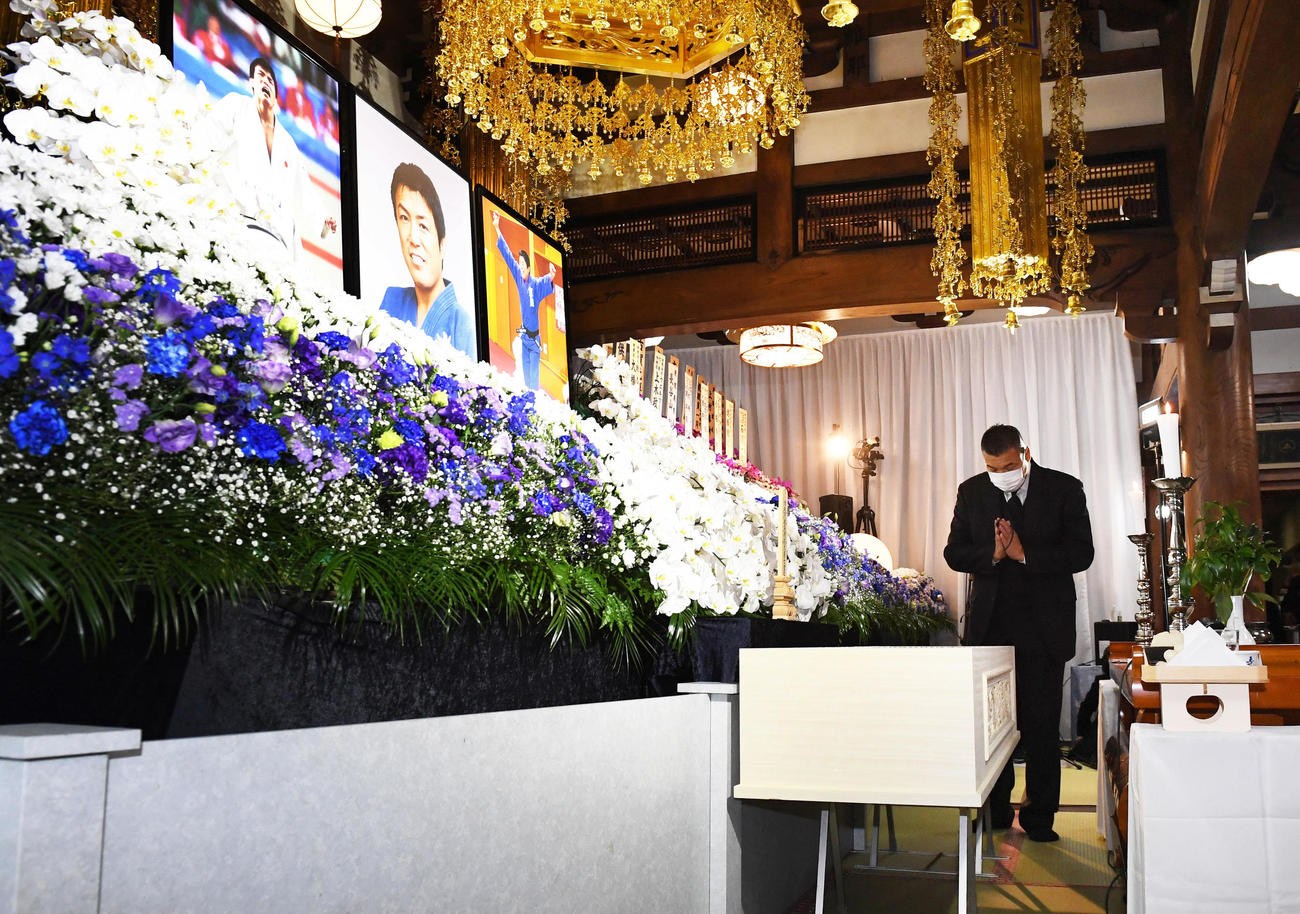 棺（ひつぎ）に向かって手を合わせる小川直也氏（代表撮影）