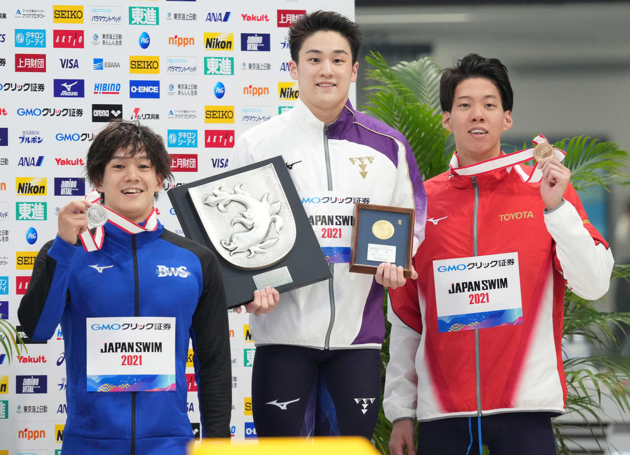 男子100メートルバ平泳ぎで優勝し笑顔の佐藤（中央）。左は2位の武良、右は3位の渡辺（撮影・鈴木みどり）