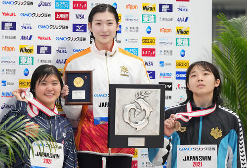 女子100メートルバタフライで優勝し笑顔の池江(中央)。左は2位の長谷川、右は3位の飯塚(撮影・鈴木みどり)