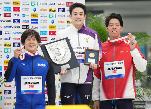 男子100メートルバ平泳ぎで優勝し笑顔の佐藤(中央)。左は2位の武良、右は3位の渡辺(撮影・鈴木みどり)