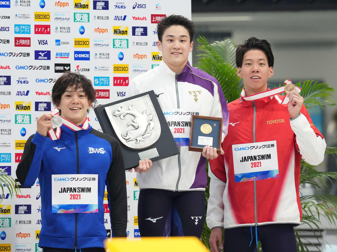 男子100メートルバ平泳ぎで優勝し笑顔の佐藤（中央）。左は2位の武良、右は3位の渡辺（撮影・鈴木みどり）