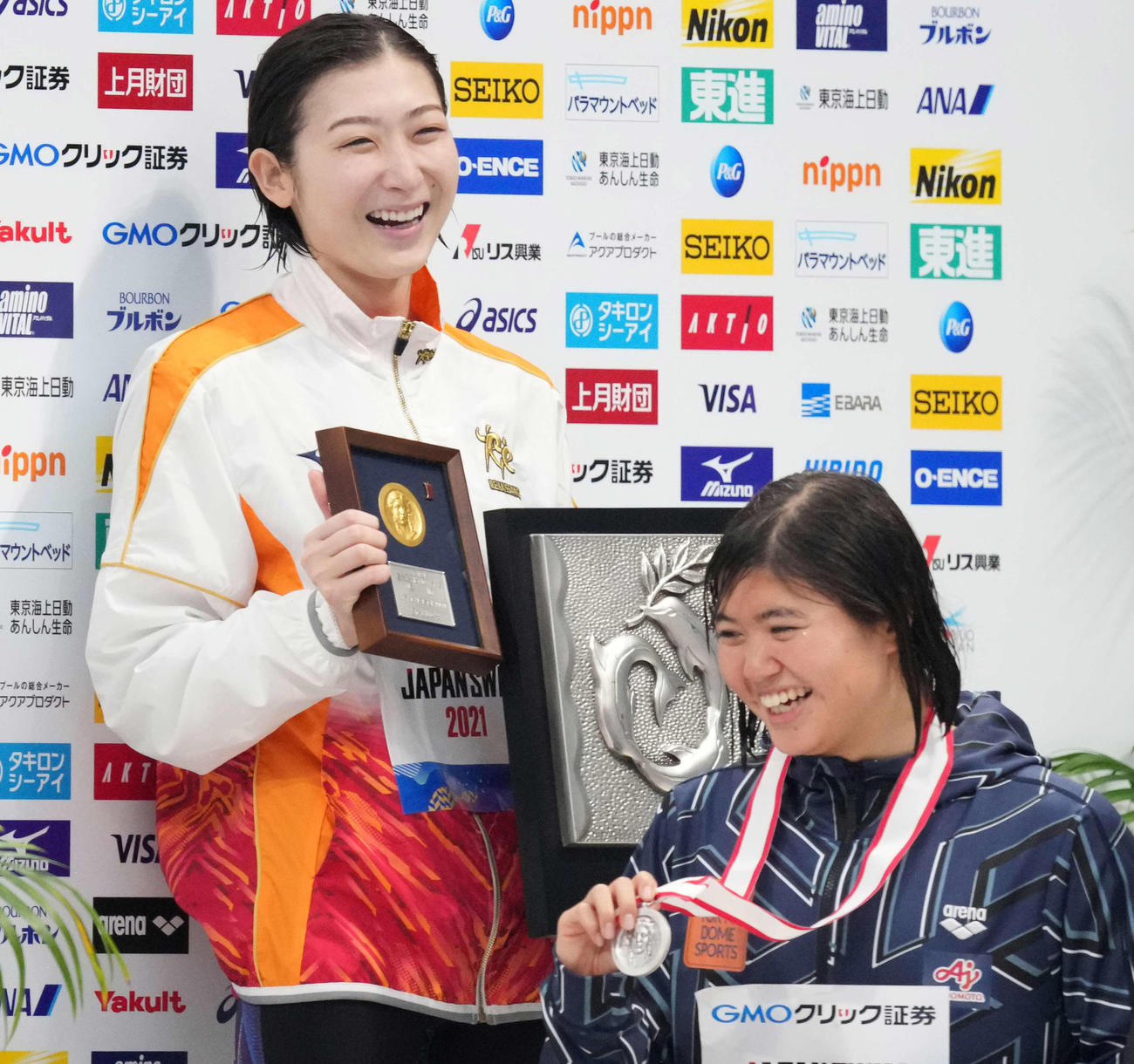 女子100メートルバタフライで優勝した池江（左）は表彰台で笑顔。右は長谷川（撮影・鈴木みどり）