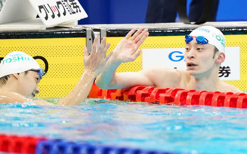 男子100メートル背泳ぎで優勝し、金子（左）とタッチをする入江（撮影・菅敏）