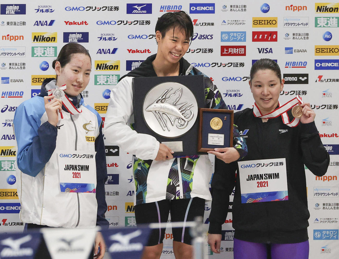 女子100メートル背泳ぎで優勝した小西（中央）。左は2位の酒井、右は3位の赤瀬（代表撮影）