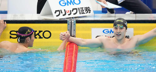 男子200メートルバタフライで東京五輪代表内定を決めた優勝の本多（左）と握手する2位の瀬戸（撮影・鈴木みどり）