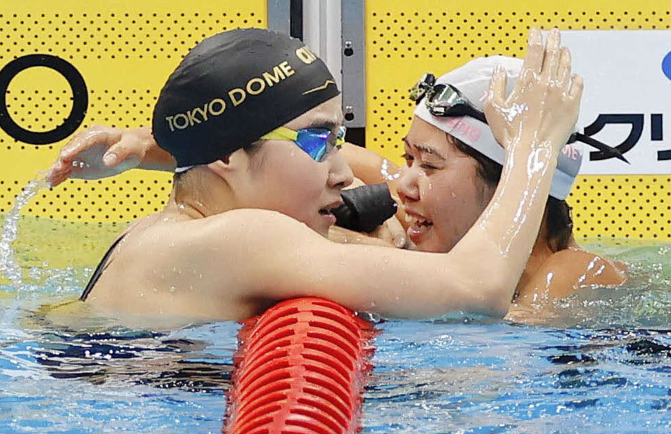 女子200メートルバタフライ決勝のレースを終え、健闘をたたえ合う優勝した長谷川（右）と2位の牧野（代表撮影）
