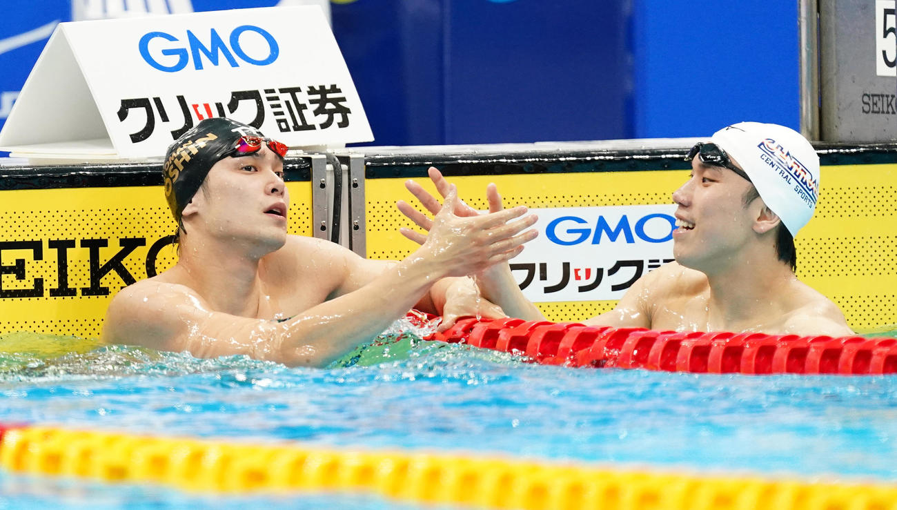 男子100メートル自由形で優勝し2位の松元（右）と握手をする中村（撮影・菅敏）