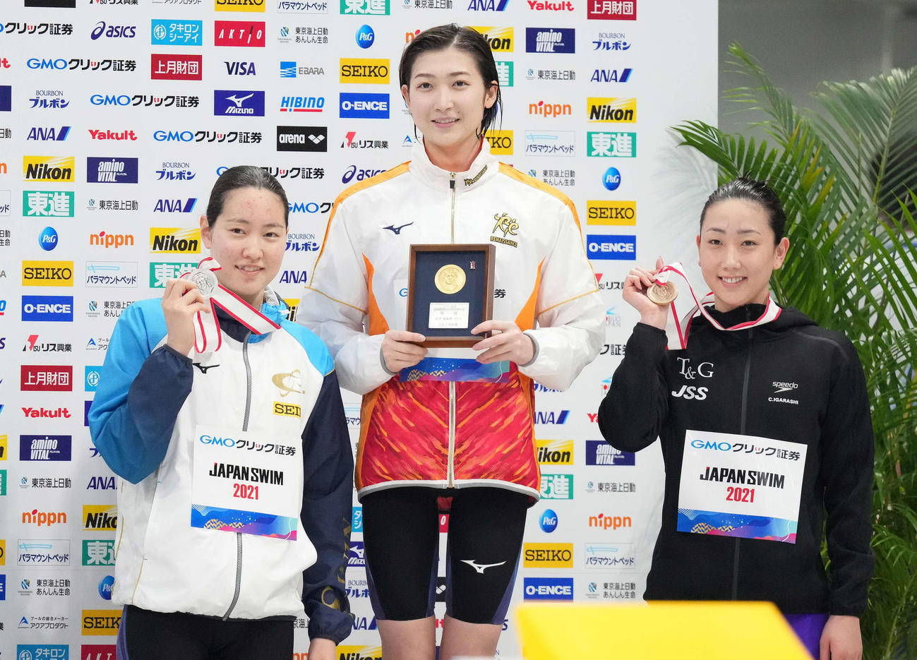 女子100メートル自由形の表彰台で笑顔を見せる優勝の池江（中央）。左は2位の酒井、右が3位の五十嵐（撮影・鈴木みどり）