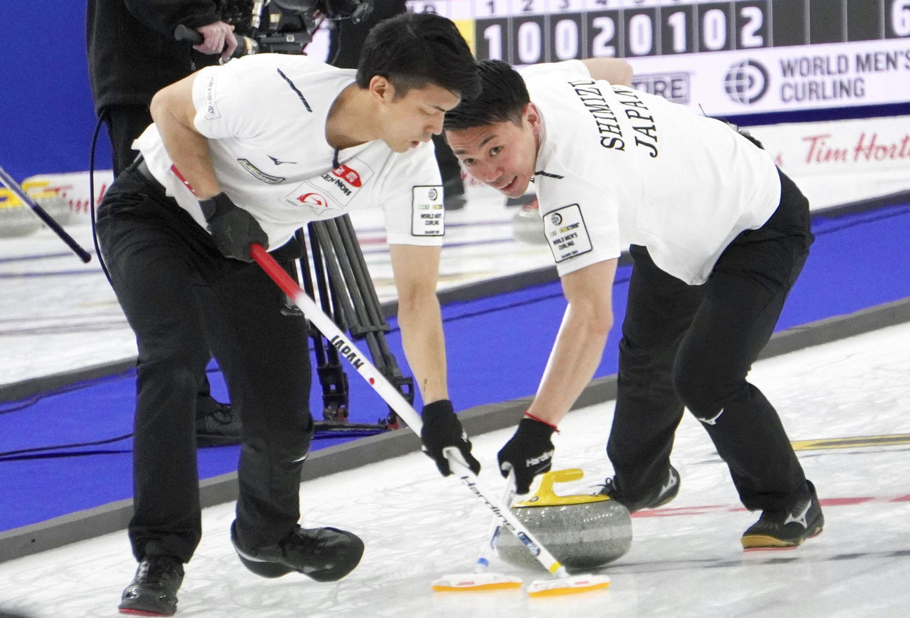 韓国戦でスイープする谷田（左）と清水（日本カーリング協会提供）（共同）