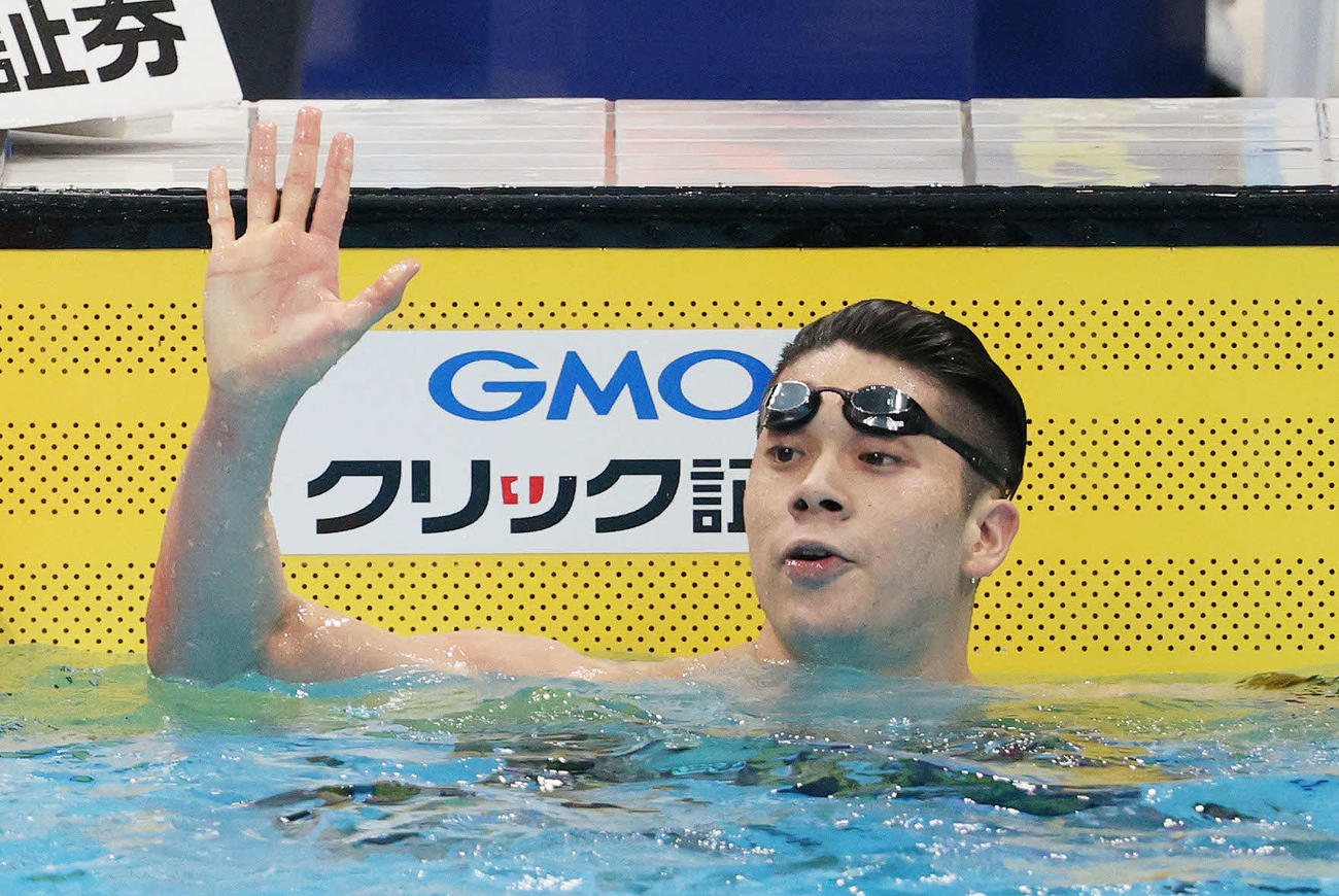 男子100メートルバタフライ決勝で派遣標準記録を突破して優勝し、手を振る水沼（代表撮影）