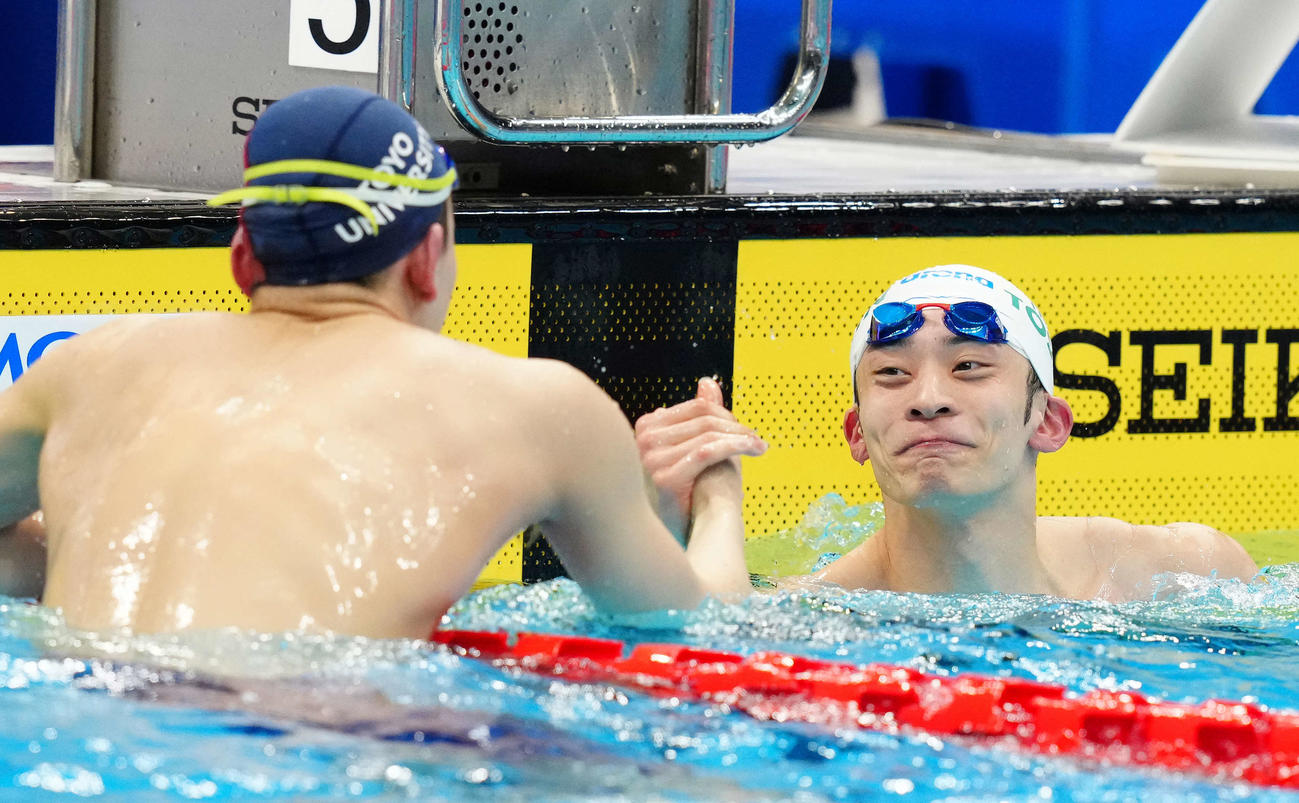 男子50メートル背泳ぎで優勝し細川（左）と握手をかわす入江（撮影・江口和貴）